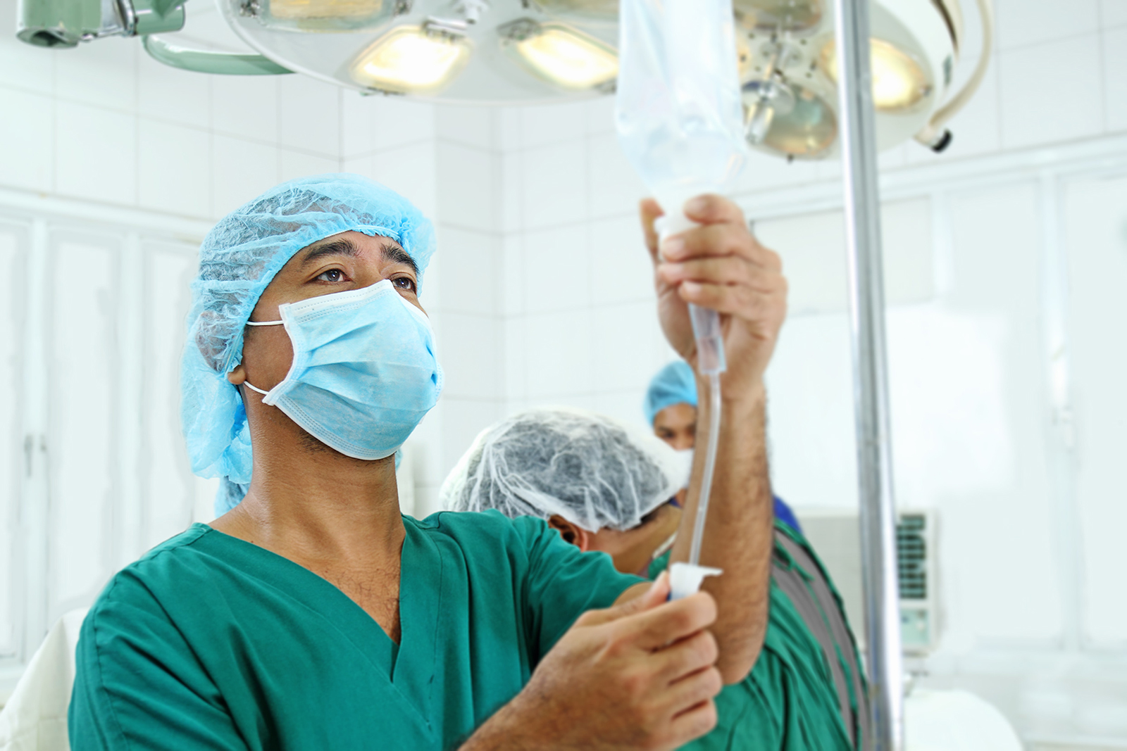Anesthesiologist adjusting IV in operating room